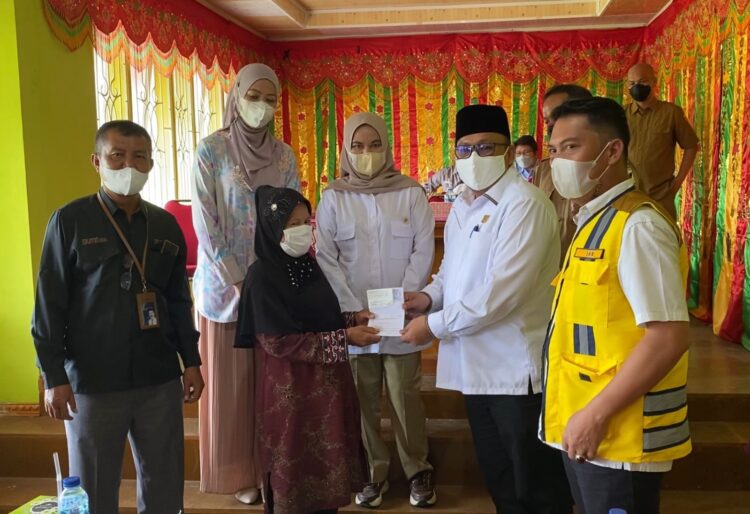 Penyerahan buku tabungan bedah rumah dari aspirasi Andre Rosiade kepada warga penerima manfaat di Nagari Batipuh Baruah, Kecamatan Batipuh, Tanahdatar.