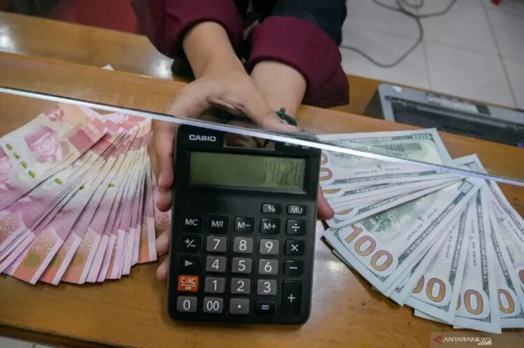 Petugas menunjukkan angka pada kalkulator di tempat penukaran uang di Melawai, Jakarta, Rabu (22/7/2020). ANTARA FOTO/Rivan Awal Lingga.