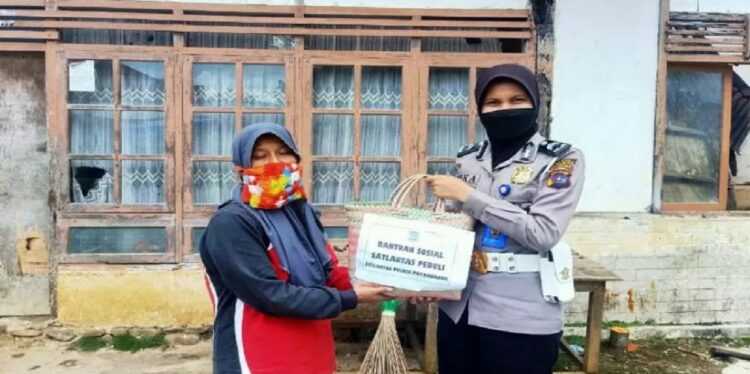 Personel Satlantas Polres Payakumbuh saat memberikan bantuan sosial kepada masyarakat. (Antara/HO-Satlantas Polres Limapuluh Kota)