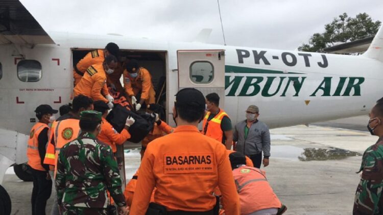 Personel SAR Timika menurunkan jenazah tiga awak pesawat Rumbun Air PK OTW dari dalam pesawat ke mobil ambulans untuk dibawa ke RSUD Mimika, Kamis (16/9/2021). (ANTARA/SAR Timika)