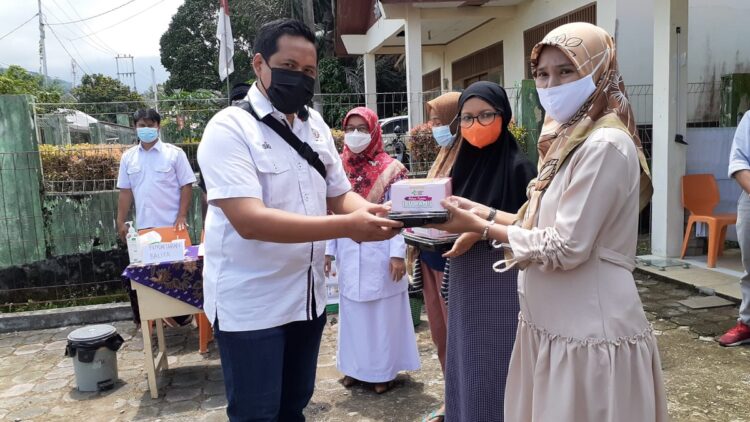 Staf Bina Lingkungan CSR Semen Padang menyerahkan bantuan makanan tambahan untuk ibu hamil di Kelurahan Limau Manis Selatan, Senin, (6/9/2021).