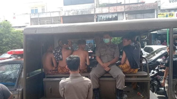 Satpol PP Padang mengamankan tiga orang anak ke atas mobil karena kedapatan ngelem. (IST)