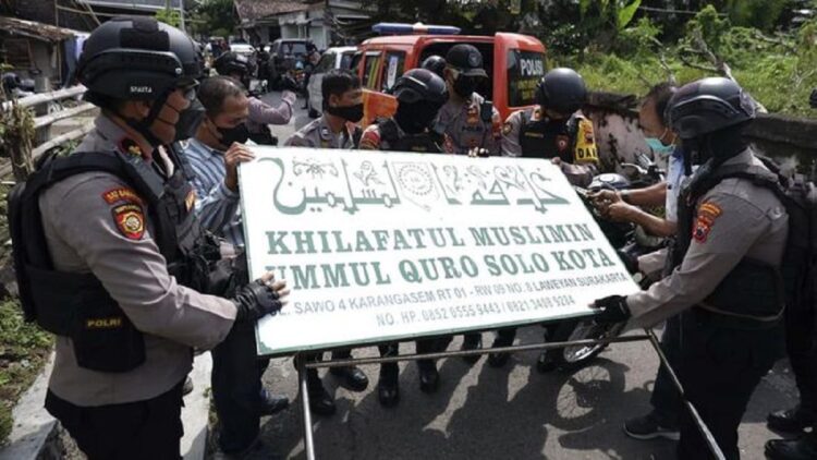 Polisi menurunkan papan bertuliskan Khilafatul Muslimin dari kantor cabang kelompok tersebut di Solo, Jawa Tengah, Kamis (9/6/2022). (ANTARA FOTO/Maulana Surya)