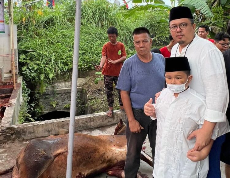 Wasekjend IKM Gerindra Braditi Moulevey bersama putranya menyaksikan penyembelihan hewan kurban di Masjid Baitul Amal, Marapalam, Padang Timur.