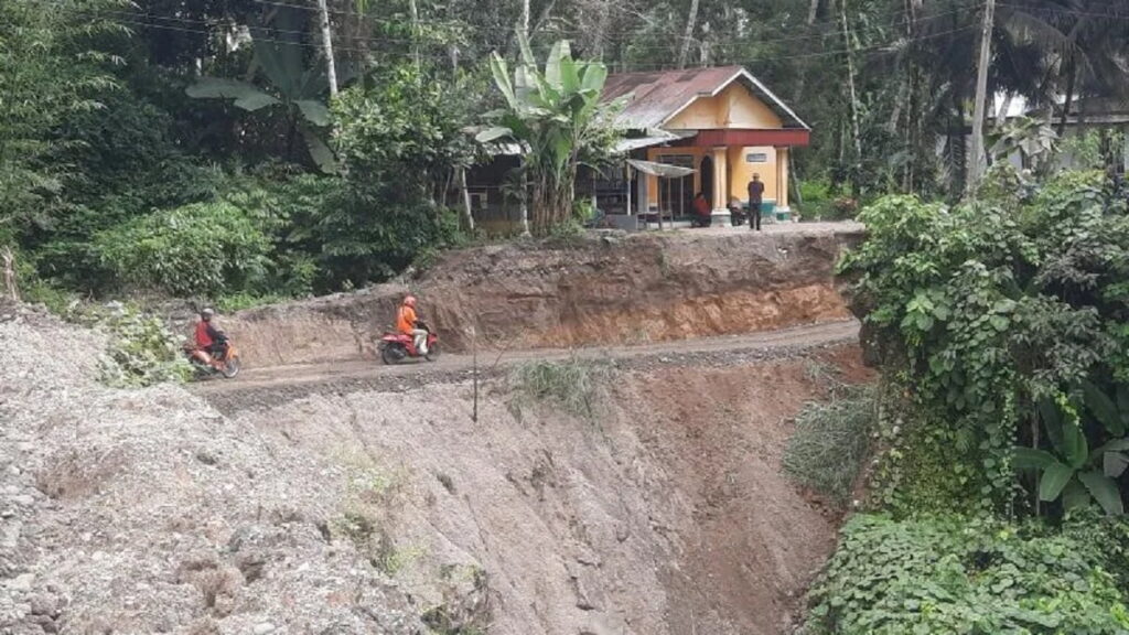 Kurir di salah satu jasa ekspedisi dan toko daring melintasi jalan darurat di Luhuang, Nagari Kuranji Hulu, Kecamatan Sungai Garinggiang, Kabupaten Padang Pariaman, Sumbar yang menghubungkan kabupaten itu dengan Kabupaten Agam. ANTARA/Aadiaat M. S.