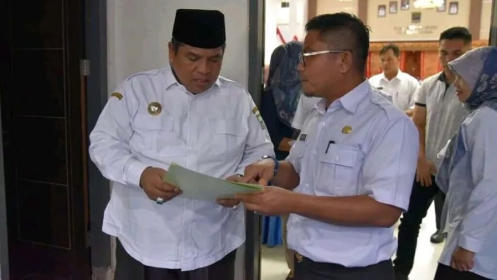 Kepala Dinas Pertanian dan Ketahanan Pangan Kabupaten Padang Pariaman, Sumbar Yurisman Yakub (kanan) menunjukkan sertifikat terdaftarnya varietas kelapa di Kementan ke Bupati Padang Pariaman. ANTARA/HO-DistanKP Padang Pariaman.