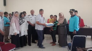 Staf CSR Semen Padang Yaldi (kiri) meneyerahkan makanan tambahan bergizi kepada Baduta Stunting di Lubuk Kilangan, Rabu (31/8/2022).