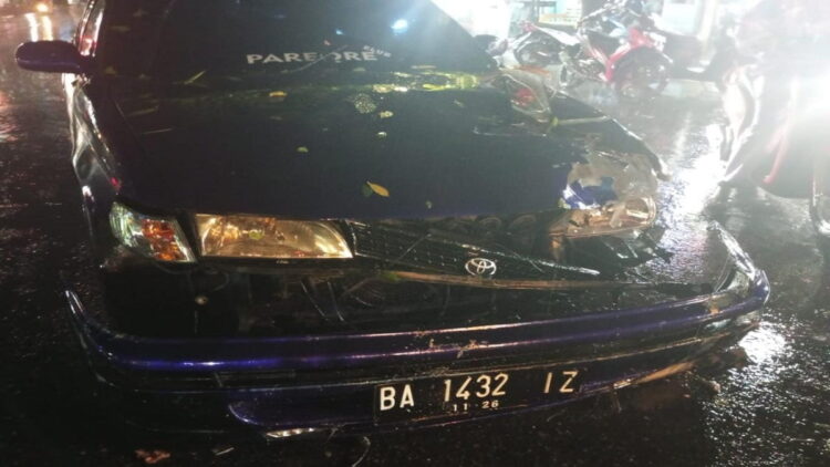 Satu unit mobil sedan ringsek setelah ditimpa pohon tumbang di Kota Padang. (IST)