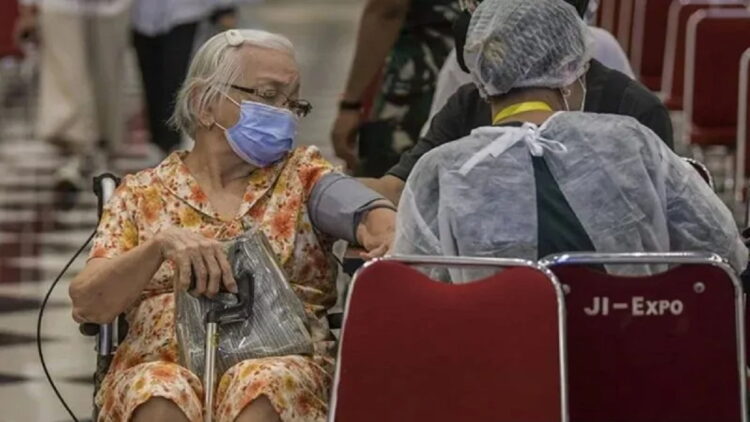 Petugas kesehatan memeriksa kesehatan warga lanjut usia (lansia) calon penerima vaksin COVID-19 dosis ketiga (booster) di Jiexpo Kemayoran, Jakarta, Selasa (25/1/2022). (ANTARA/Galih Pradipta).