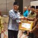 Gubernur Sumbar, Mahyeldi saat menyerahkan penghargaan pada Sekdakab Agam, Edi Busti.