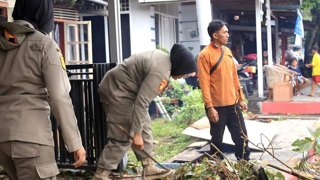 Praja Wanita Satpol PP Kota Padang membantu evakuasi dan memindahkan barang warga korban terdampak pohon tumbang pada Kamis (22/12/2022) pagi dalam rangka Hari Ibu. (Foto: Dok. Satpol PP)