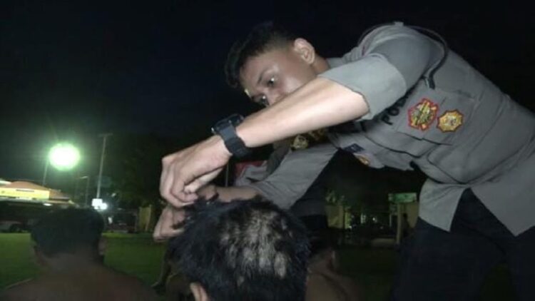 Personel Polresta Padang memotong rambut salah seorang pelaku tawuran di Padang. (Foto: radarsumbar.com/Herru Iriawan)