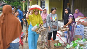 Warga Batu Busuk yang jadi korban banjir, tampak bahagia menerima bantuan paket sembako dari PT Semen Padang. (Dok. Humas)