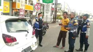 Petugas Dishub Kota Padang memberi imbauan kepada salah seorang tukang parkir yang mengenai badan jalan. (Dok. Dishub Padang)