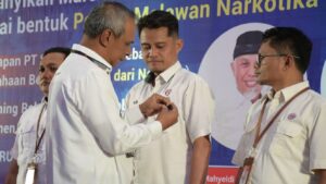 Dirut Semen Padang sematkan pin kepada karyawan berprestasi yang menjadi relawan Anti Narkoba. (Dok. Humas)