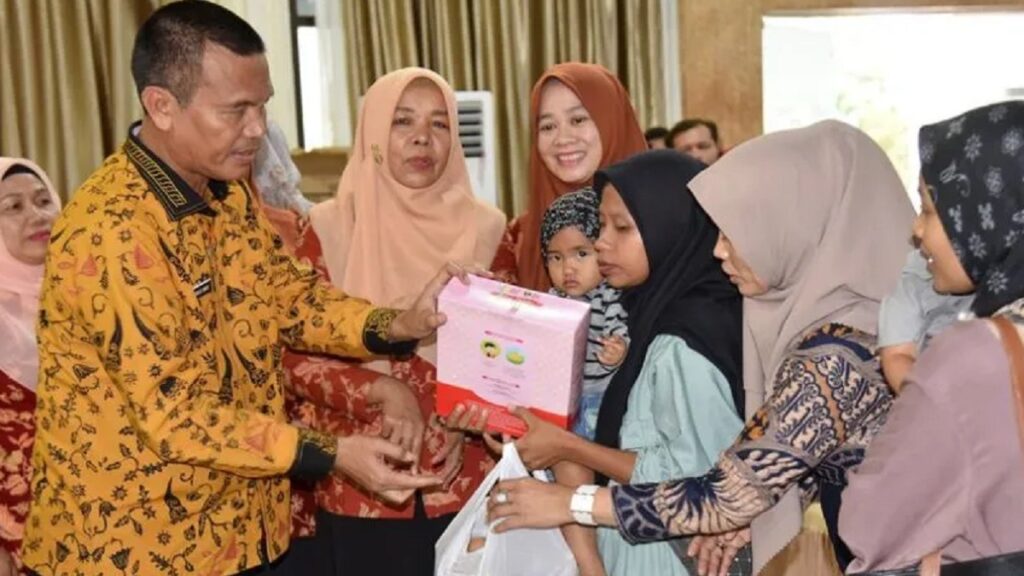 Wali Kota Pariaman Genius Umar (kiri) secara simbolis memberikan bantuan makanan, susu, dan biskuit kepada keluarga anak berisiko stunting saat peluncuran Bapak Asuh Anak Stunting di Pariaman. (ANTARA/HO-Diskominfo Pariaman)