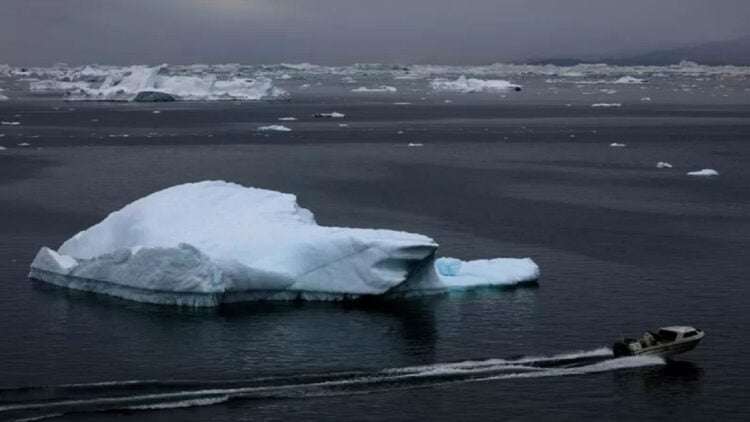 Sebuah perahu motor melintas dekat gunung es yang mengapung di Disko Bay, dekat Ilulisat, Greenland, Selasa (14/9/2021). Peneliti menyatakan lapisan es Greenland mengalami pencairan besar-besaran akibat kenaikan suhu bumi yang di atas rata-rata. ANTARA FOTO/ REUTERS/Hannibal Hanschke/foc.