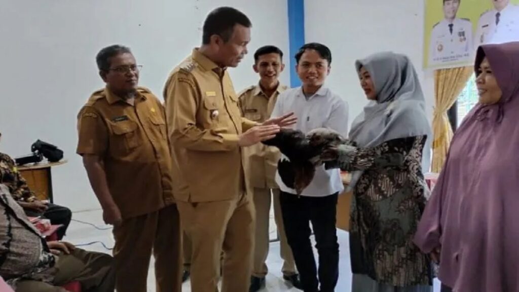 Wako Pariaman, Sumbar Genius Umar (kiri) secara simbolis memberikan bantuan ternak ayam kepada peternak di Pariaman. (ANTARA/HO-Diskominfo Pariaman)