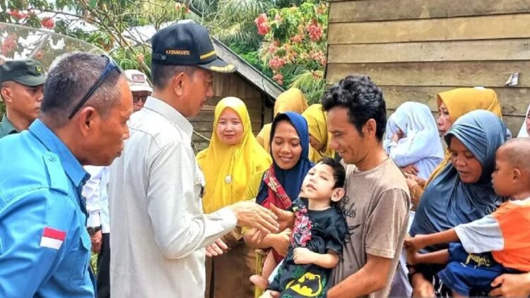Wakil Bupati Pasaman Barat Risnawanto saat mengunjungi dan membantu dua orang anak yang mengalami gizi buruk di Jorong Pigogah Kecamatan Sungai Beremas pada Senin (12/6). (Antara/HO-Kominfo Pasbar).