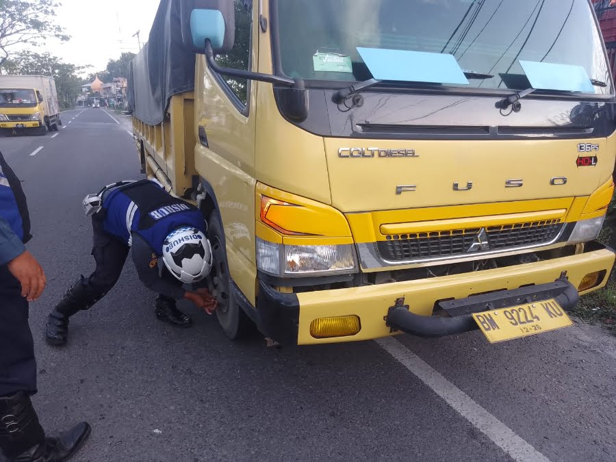 Petugas gabungan mengempeskan ban truk yang parkir secara sembarangan. (Dok. Dishub Padang)