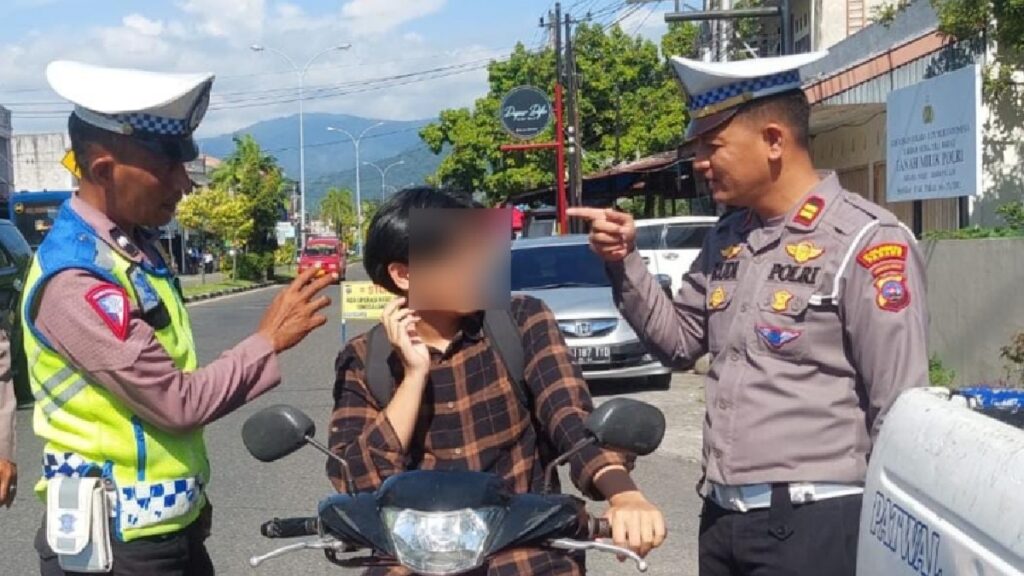 Kanit Turjawali Satlantas Polresta Padang, Iptu Rudi Chandra (kanan) menegur salah seorang pemotor yang tak menggunakan helm. (Dok. Satlantas)