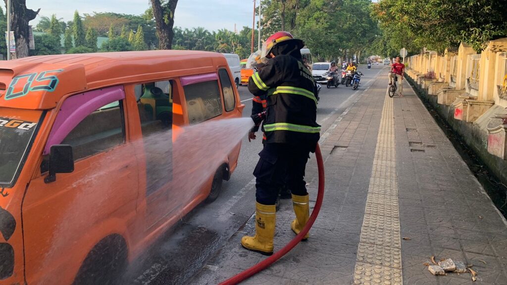 Personel Damkar Kota Padang memadamkan api dari sebuah angkot di depan kampus UNP, Sabtu pagi. (dok. Damkar Kota Padang)