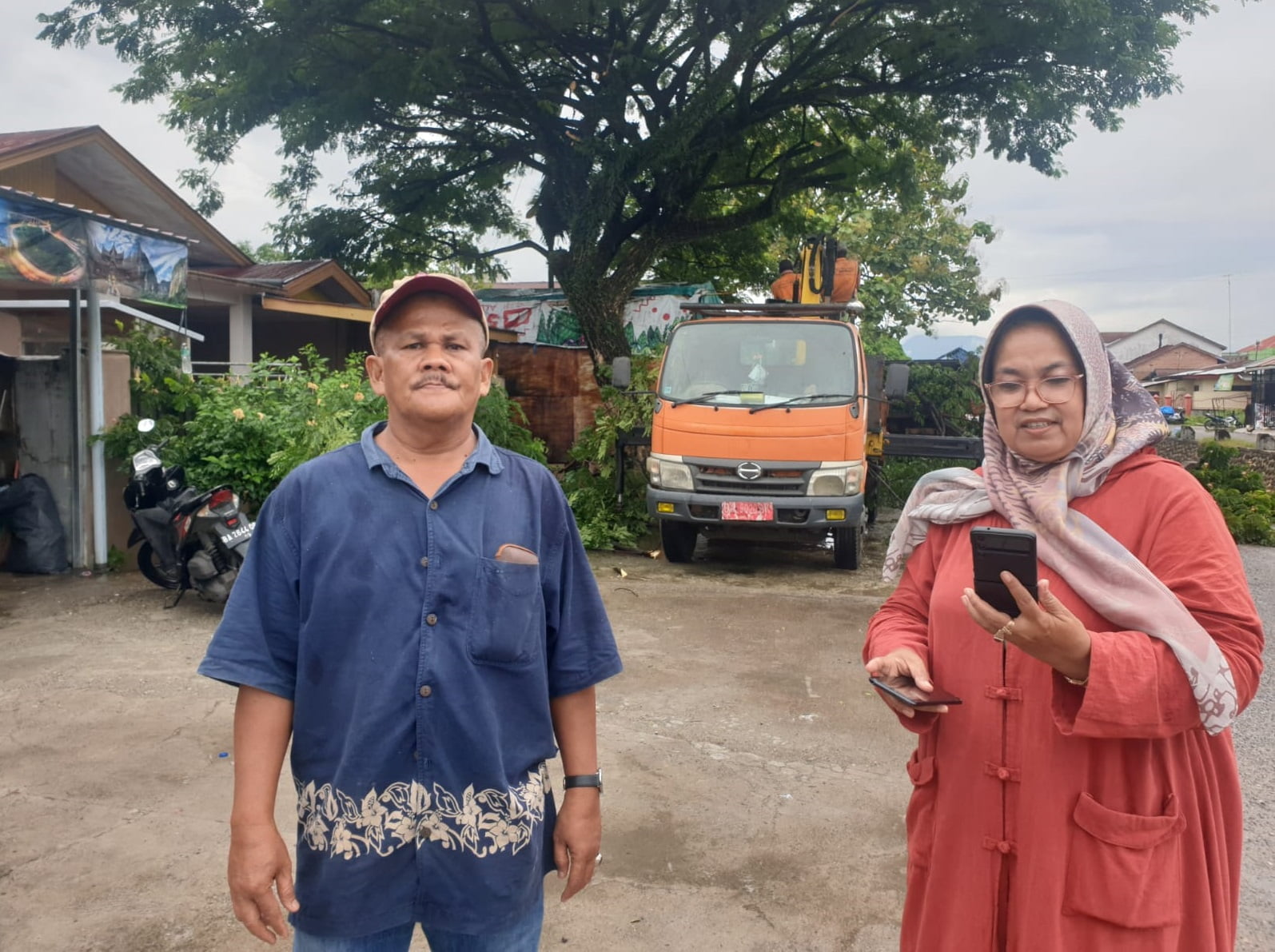 Caleg Partai Gerindra dapil Sumbar 1, Maiyofa (baju oren) bersama Ketua RT 3, Edison di lokasi pemotongan pohon. (dok. istimewa)