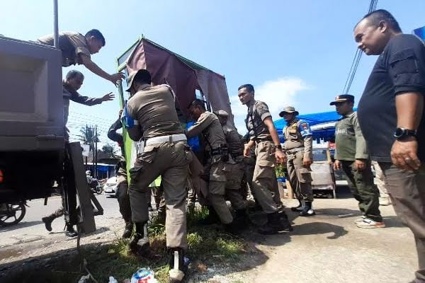 Petugas penegak Perda mengangkat lapak yang ditinggal oleh Pedagang Kaki Lima (PKL) di Padang. (Foto: Dok. Istimewa)