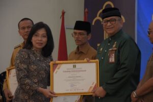 Sekretaris Daerah (Sekda) Kota Padang, Andree Harmadi Algamar (kanan) menerima penghargaan kekayaan intelektual dari Kemenkumham RI. (Foto: Dok. Diskominfo Padang)