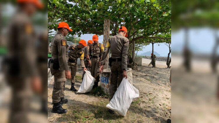Aparat Satpol PP Padang memunguti sampah yang berserakan di Pantai Padang. (Foto: Dok. Humas Satpol PP Padang)