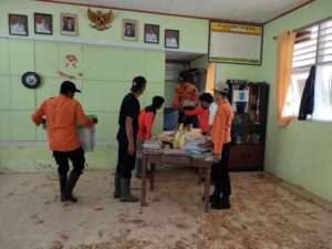 Petugas BPBD Kabupaten Limapuluh Kota membersihkan sisa material lumpur yang masuk ke dalam sekolah pasca banjir pada Selasa (24/10/2023) malam. (Foto: Dok. Pusdalops PB)