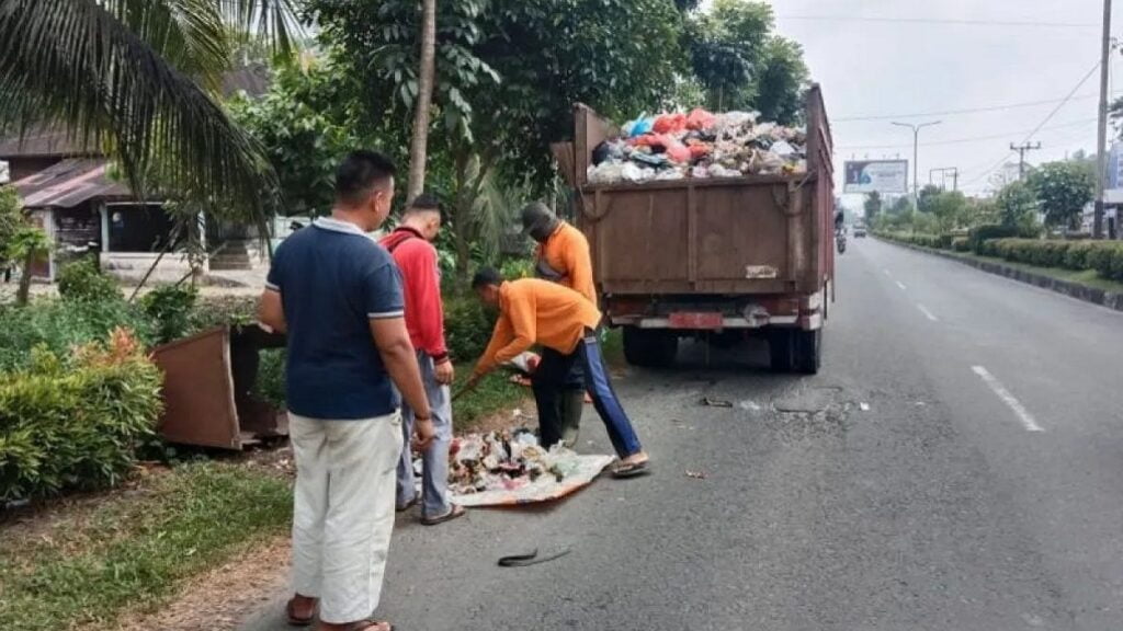 Petugas DLH Agam sedang membersihkan sampah. (dok. Antara)