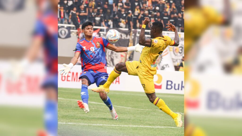 Striker Semen Padang FC Kenneth Ngwoke berebut bola dengan kiper Sriwijaya FC. (dok. Semen Padang FC)