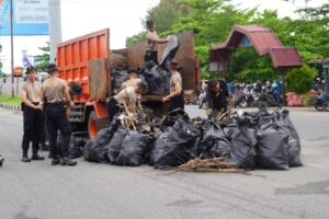 Personel kepolisian membersihkan dan mengangkut sampah yang berserakan di Pantai Padang pada Selasa (6/2/2024) pagi. (Foto: Dok. Prokopim)