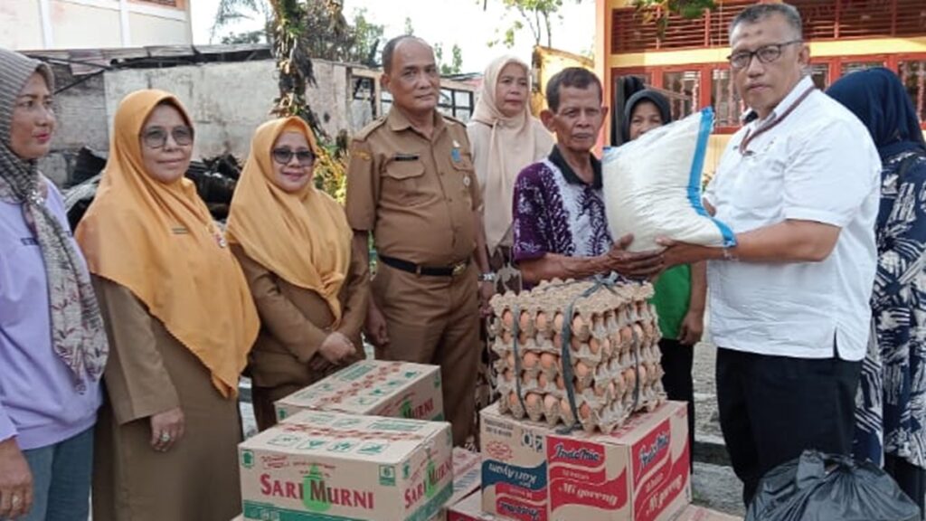 Ka Sie TJSL Unit CSR PT Semen Padang, Nurwan, menyerahkan bantuan sembako kepada Rusdi, penjaga sekolah SD Negeri 37 Pagambiran Nan XX, Kecamatan Lubuk Begalung, Kota Padang, Senin (12/2/2024). Bantuan sembako itu diserahkan sebagai bentuk kepedulian PT Semen Padang kepada korban kebakaran. (dok. Humas)