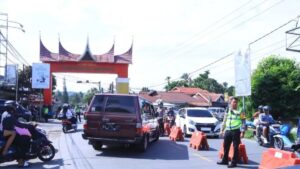 Personel Kepolisian mengatur arus lalu lintas di pintu masuk kawasan wisata Harau, Limapuluh Kota, Sumatra Barat (Sumbar) pada Jumat (12/4). (ANTARA/FathulAbdi)