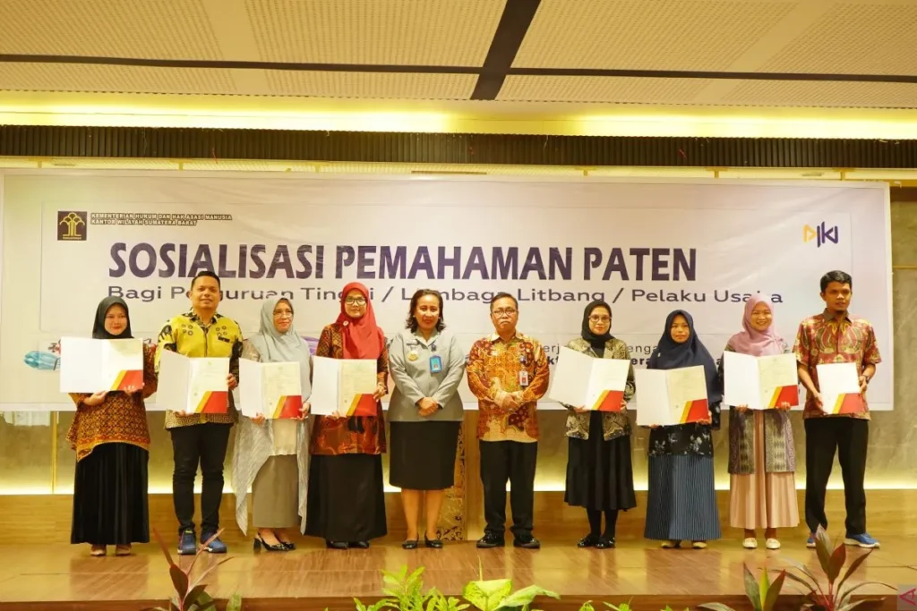 Divisi Pelayanan Hukum dan HAM Kemenkumham Sumbar Ruliana Pendah Harsiwi menyerahkan sertifikat hak kekayaan intelektual di Padang. (Foto: Dok. Antara/HO-Humas Unand).