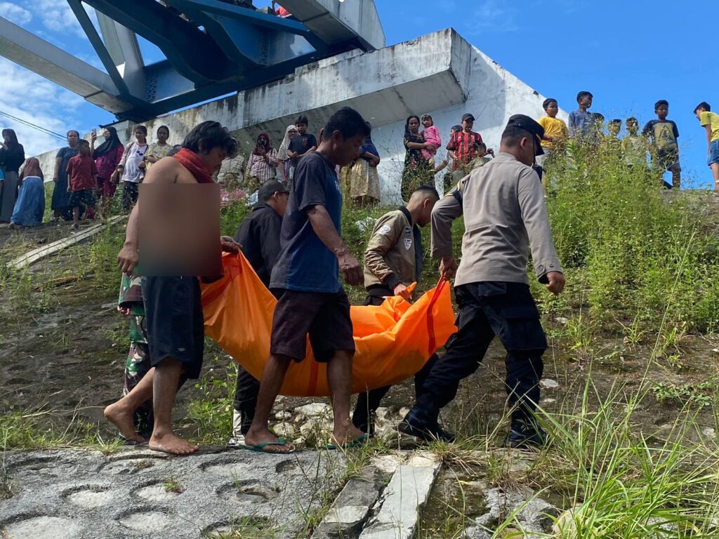 Petugas mengevakuasi jasad dari Zainorawati (52) yang ditemukan meninggal dunia di bawah jembatan kereta api kawasan Kampung Baru Nan XX pada Senin (1/7/2024) pagi. (Foto: Dok. Polsek Lubuk Begalung)