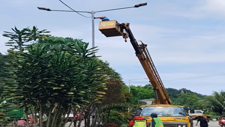 Petugas memperbaiki lampu penerangan jalan umum yang rusak. (Foto: Dok. Diskominfo Padang)