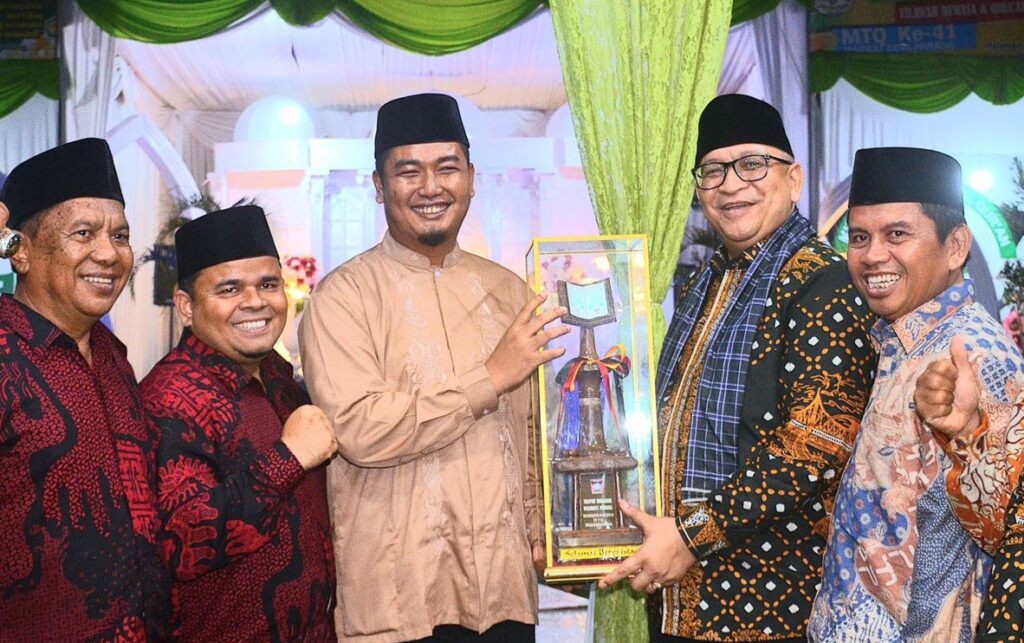 Camat Koto Tangah, Fizlan Setiawan menerima trofi juara MTQN ke-41 Tingkat Kota Padang dari Pj Wako Padang, Andree Harmadi Algamar. (Foto: Dok. Prokopim)