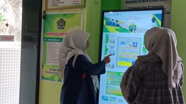 Dua orang karyawan di KUA Kota Solok saat melihat aplikasi digitalisasi dalam meningkatkan aksesibilitas layanan publik di kota itu. (ANTARA/HO-Diskominfo Solok)