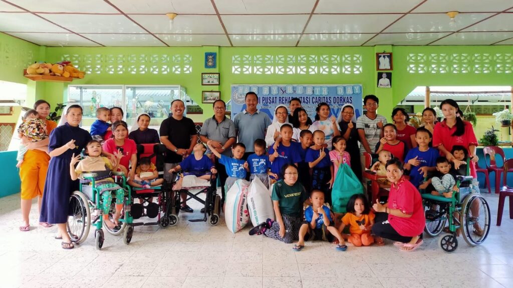 Para anak-anak di Pusat Rehabilitasi Caritas Dorkas sambut Ketua DPD Partai Golkar Kota Gunungsitoli Martinus Lase dan berfoto bersama pada Selasa (10/9/2024). (Kariadil Harefa/Radarsumbar)