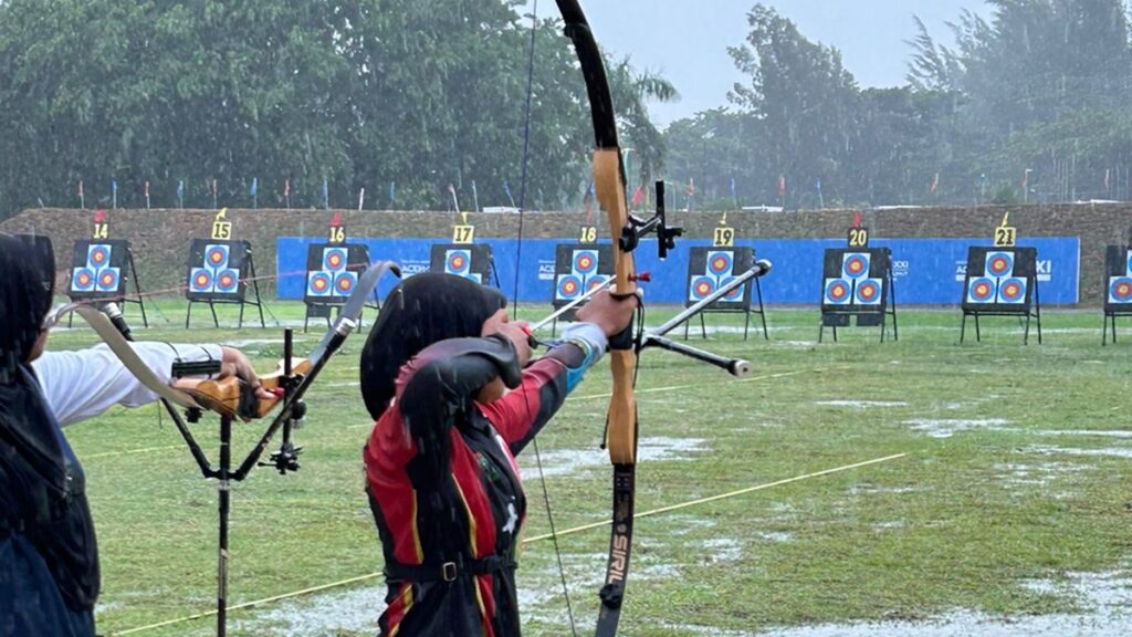 Atlet panahan Sumbar tetap bertanding meski hujan deras mengguyur arena PON XXI. (dok. istimewa)