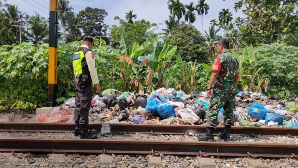 Petugas dari KAI Divre II Sumbar memeriksa kondisi ruas rel yang dijadikan tempat sampah.