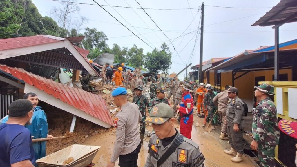 Petugas gabungan membersihkan material longsor yang menghantam rumah warga di Batam. (dok. BNPB)