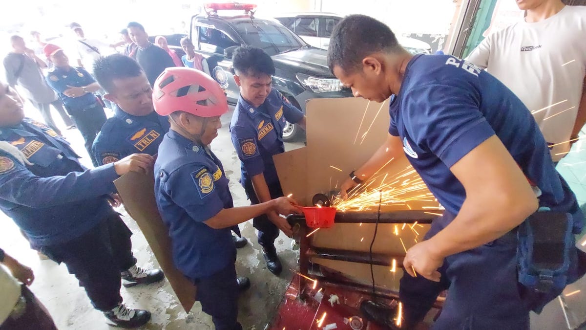 Petugas Damkar Kota Padang mengeluarkan tangan bocah yang tersangkut pipa besi. (dok. istimewa)