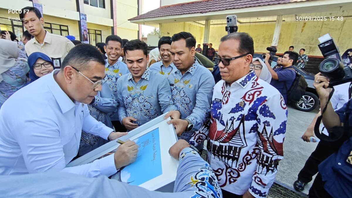Wamen ATR/BPN, Ossy Dermawan saat menandatangi karya seni buatan pegawai BPN Padang di sela penyerahan sertifikat untuk masyarakat di Padang. (dok. Radarsumbar)