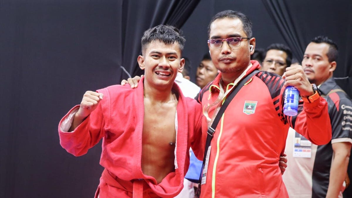 Pelatih Sambo Sumbar Hendri Gusman Darma bersama peraih emas pertama Sambo di PON Beladiri, Yusril Mahendra. (dok. Humas KONI Sumbar)