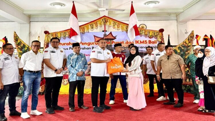 Ketum IKM Andre Rosiade menyerahkan bantuan uang tunai dan paket sembako untuk korban banjir di Bali. (Foto: Ist)