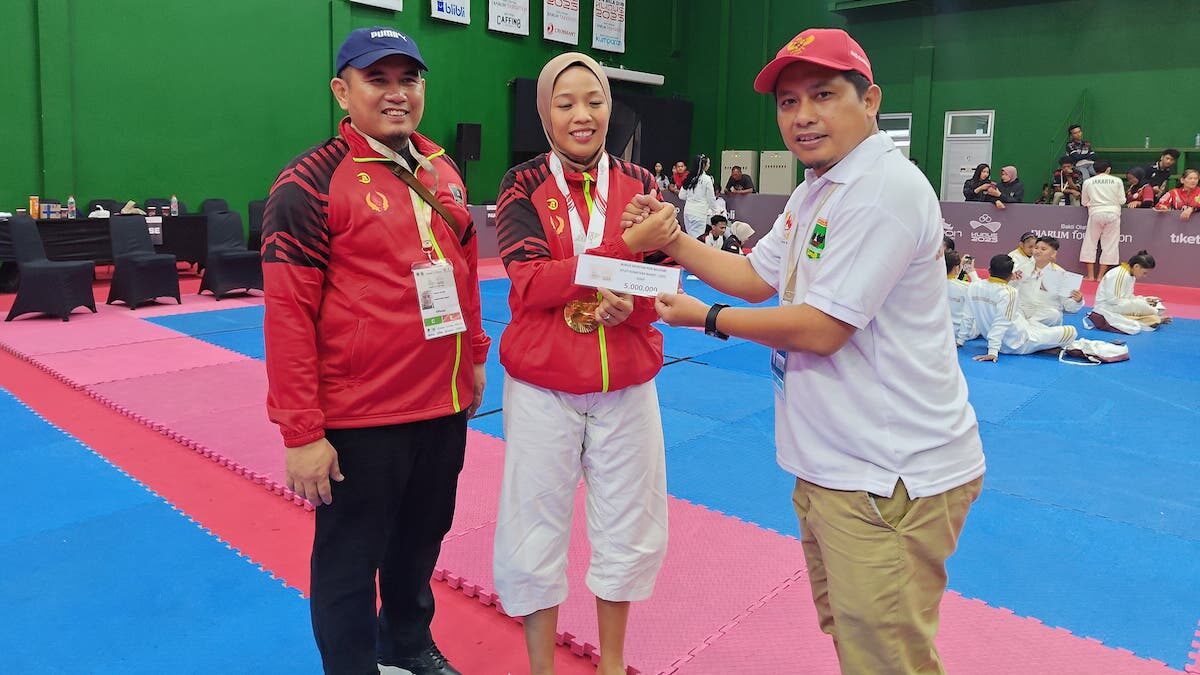 Ketua Umum KONI Sumbar Hamdanus disaksikan Wakil Ketua Umum Nurul Ikhsan menyerahkan bonus spontan kepada peraih medali emas Kempo Putri Suci Kurnia Dewi. (Foto: Humas KONI Sumbar)